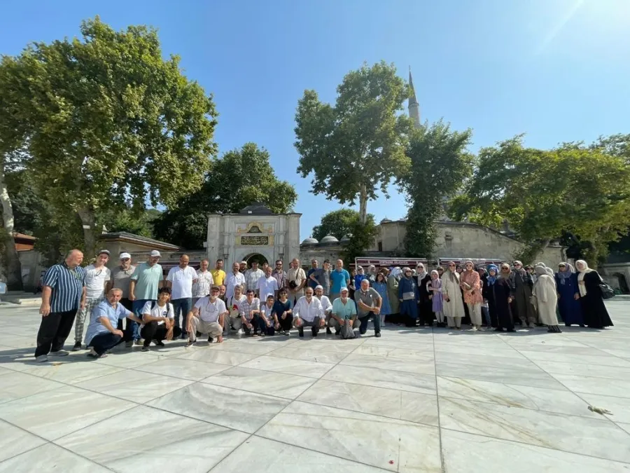 Avluda toplu hatıra fotoğrafı çektiren kalabalık bir grup